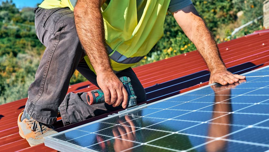 Handwerker montiert PV-Modul auf dem Dach – Photovoltaik-Integration für Eigenverbrauch