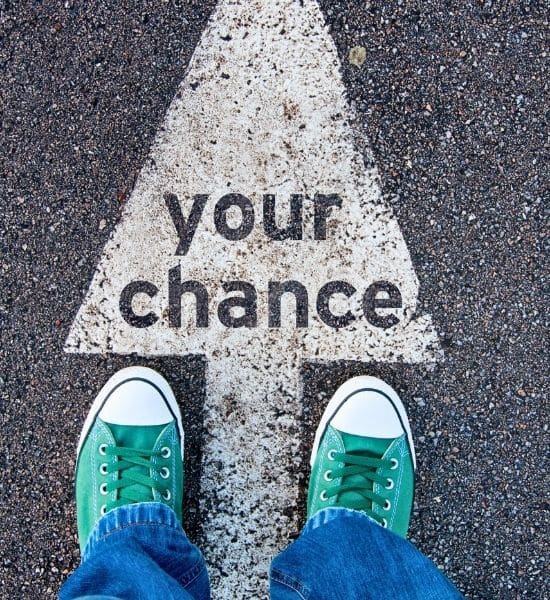 Person steht vor einem Pfeil mit der Aufschrift „Your Chance“ als Symbol für Chancen durch dynamische Stromtarife.