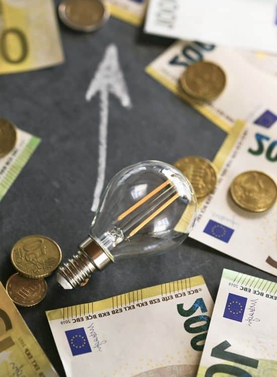 Glühbirne und Euro-Banknoten als Symbol für steigende Energiekosten und Energieeinsparungen.